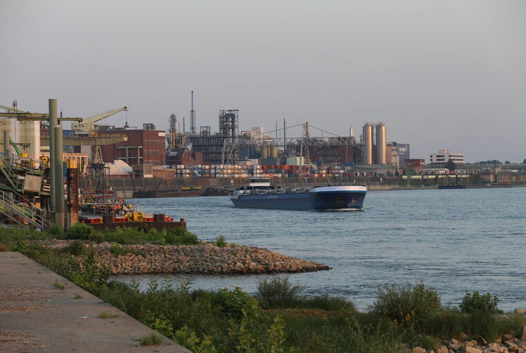 Der Rhein mit einem Schiff und Industrie im Hintergrund