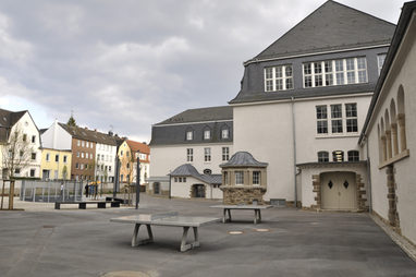 Das sanierte Schulgebäude und der Schulhof mit neuen Spielangeboten.