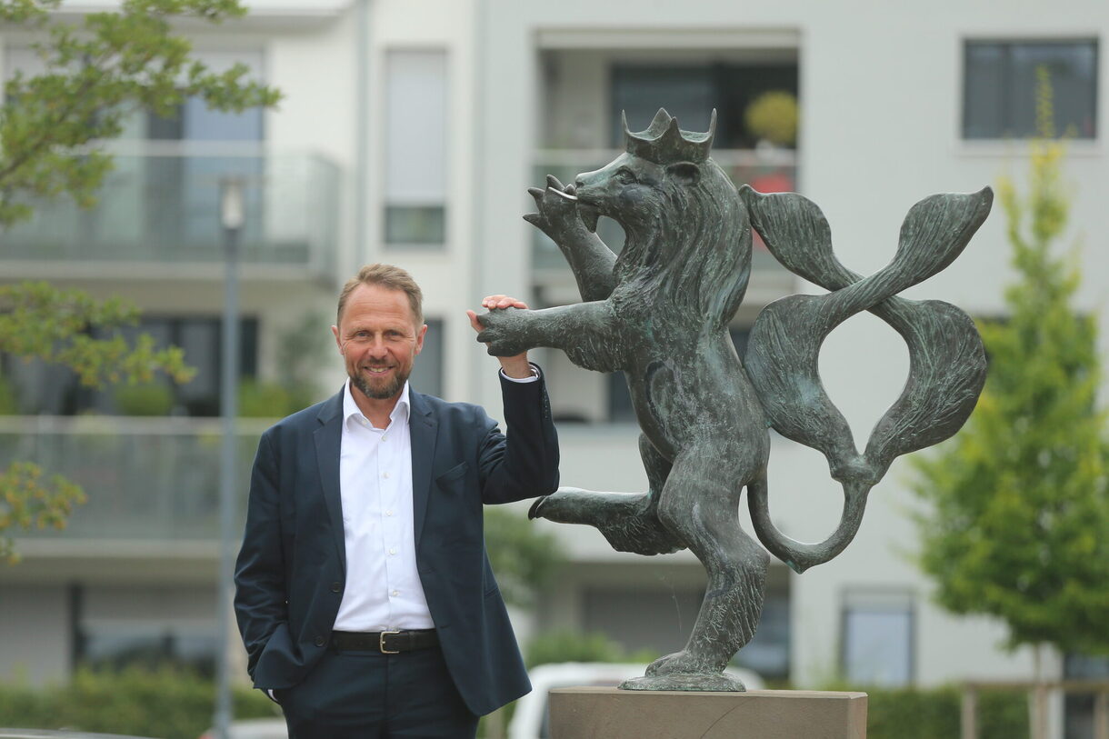 Oberbürgermeister Uwe Richrath neben einer Skulptur des Bergischen Löwen