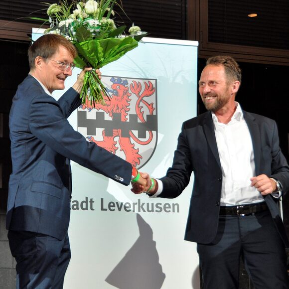 Oberbürgermeister Uwe Richrath gratuliert Karl Lauterbach am Wahlabend 2021 mit einen Blumenstrauß.