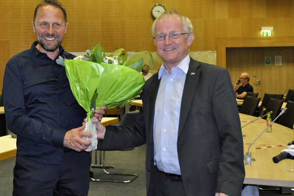 Oberbürgermeister Uwe Richrath gratuliert Rüdiger Scholz mit einen Blumenstrauß