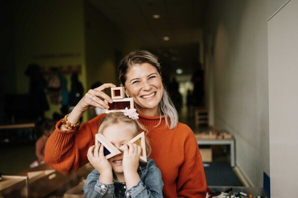 Eine Frau und ein Kind spielen vergnügt mit Bauklötzen