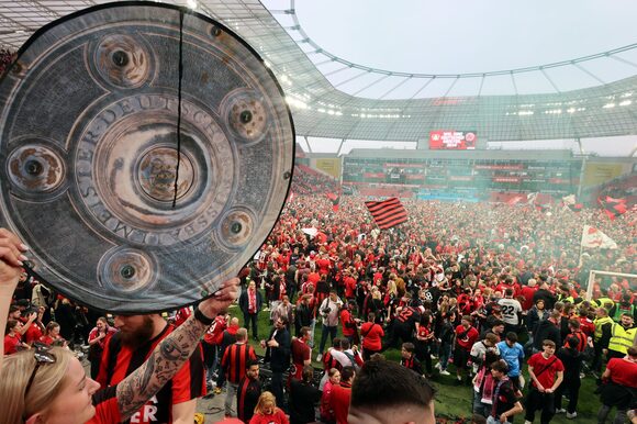 Fans von Bayer 04 stehen um Stadion und feiern