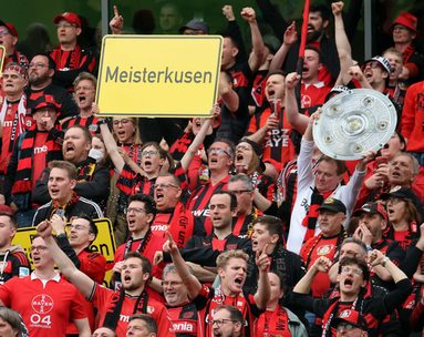 Fans im Stadion mit Schild "Meisterkusen"