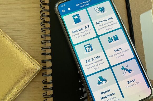 Auf einem Smartphone ist die Senioren-App "Gut versorgt in" geöffnet