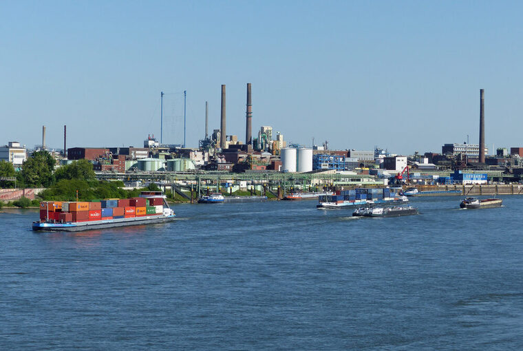 Chempark und im Vordergrund fahren Schiffe auf dem Rhein