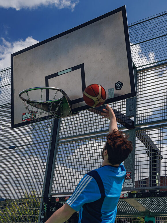 Mann wirf Ball in Basketballkorb