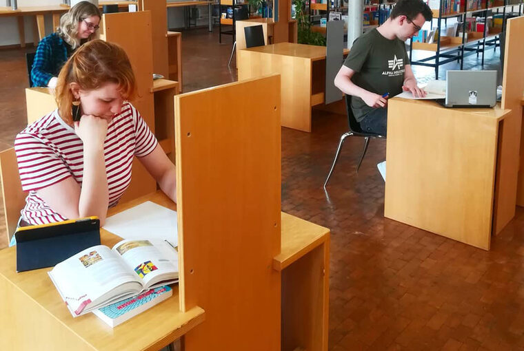 Drei Personen nutzen die Stadtbibliothek als Lernort