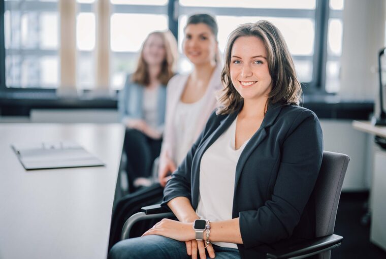 Drei junge Menschen sitzen am Tisch