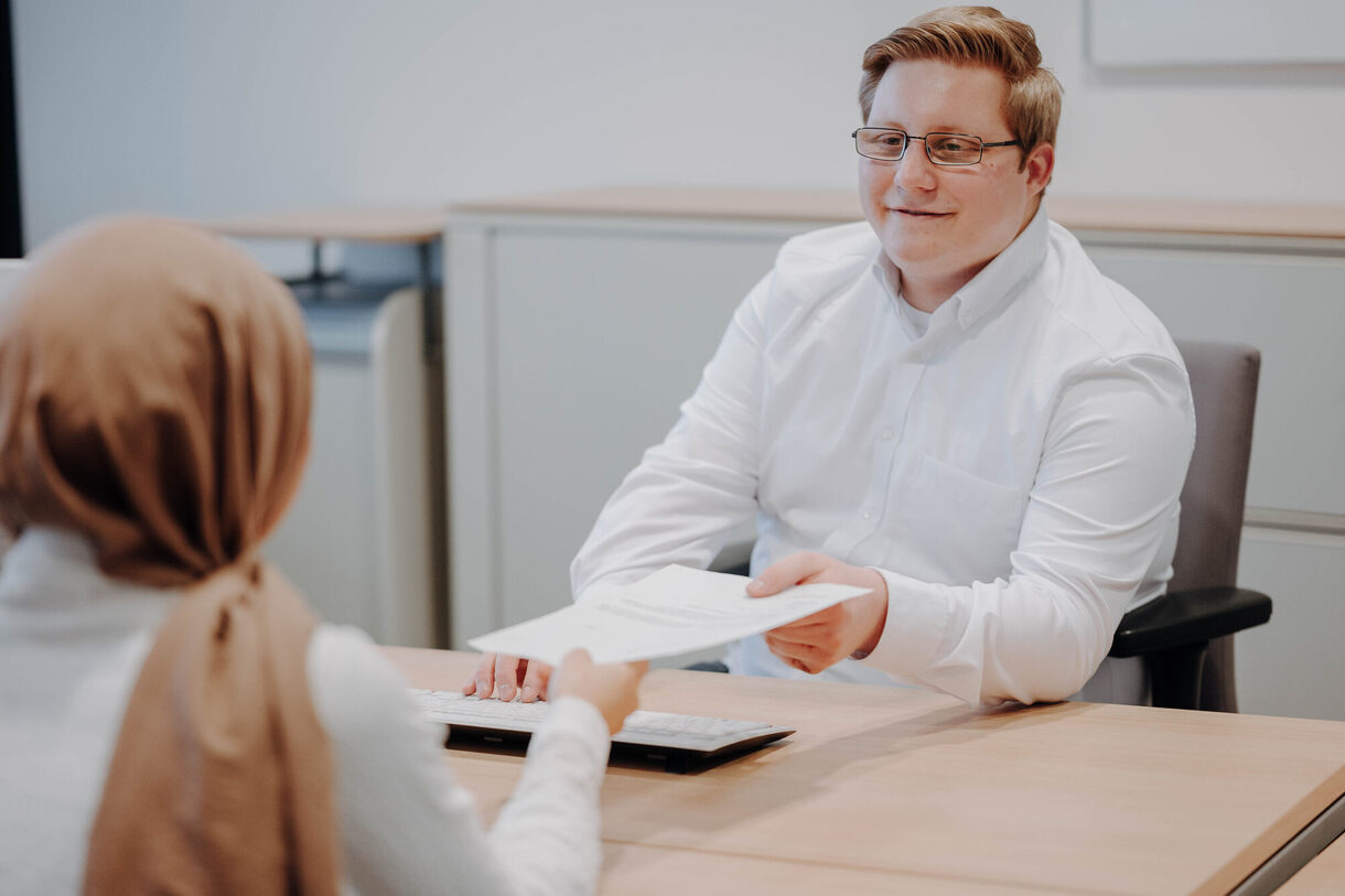 Zwei Personen sitzen am Tisch und tauschen sich aus