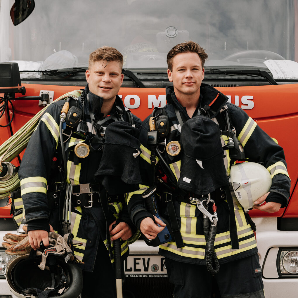 Feuerwehrmänner vor Fahrzeug