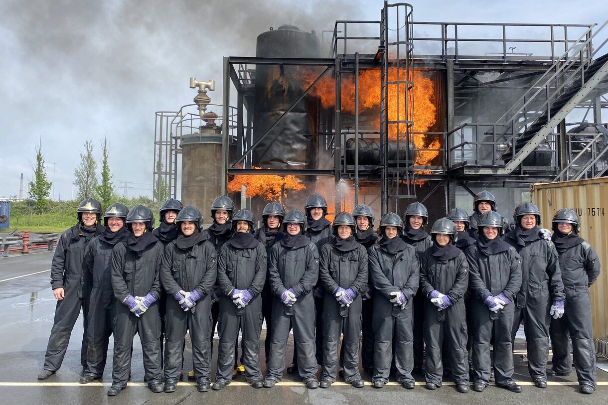 Feuerwehrleute vor brennendem Industriegebäude