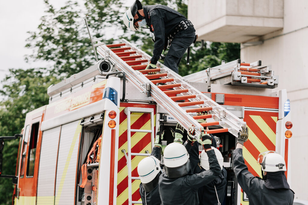 Feuerwehrleute bei Übung vor Löschfahrzeug