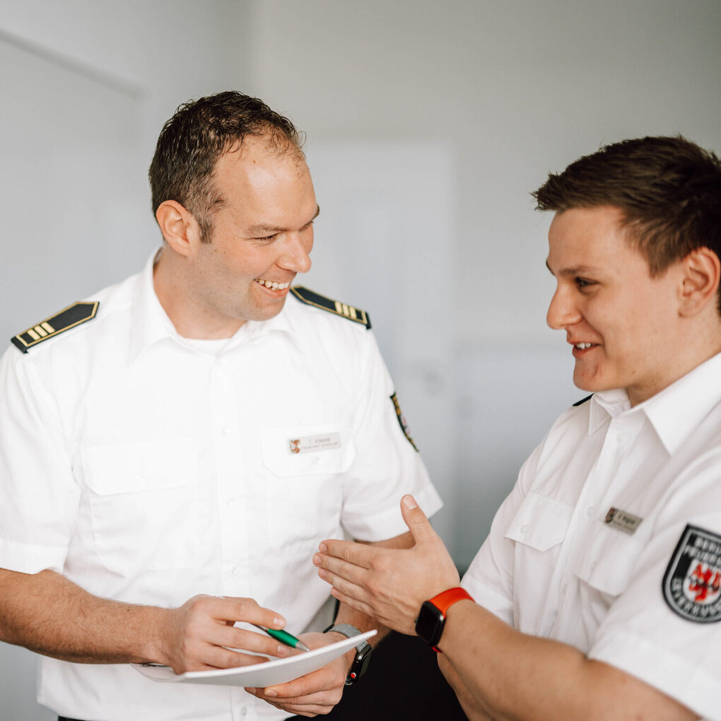 drei Feuerwehrleute in weißem Hemd