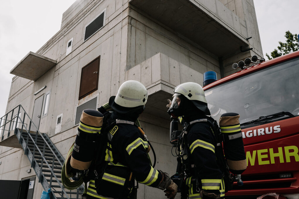 Feuerwehrleute vor Gebäude