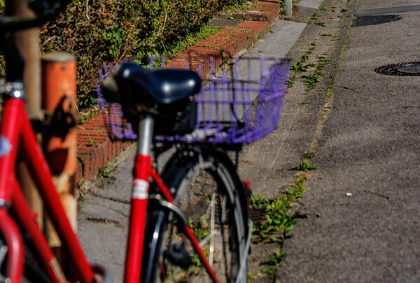 Ein rotes Fahrrad lehnt an einer Laterne